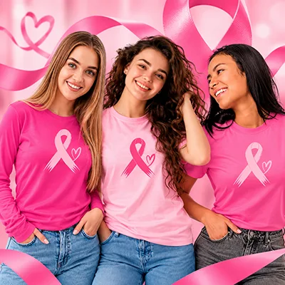Tres mujeres con playeras personalizadas rosas y listones de concientización sobre el cáncer de mama en la campaña Mes Rosa de octubre en CDMX.